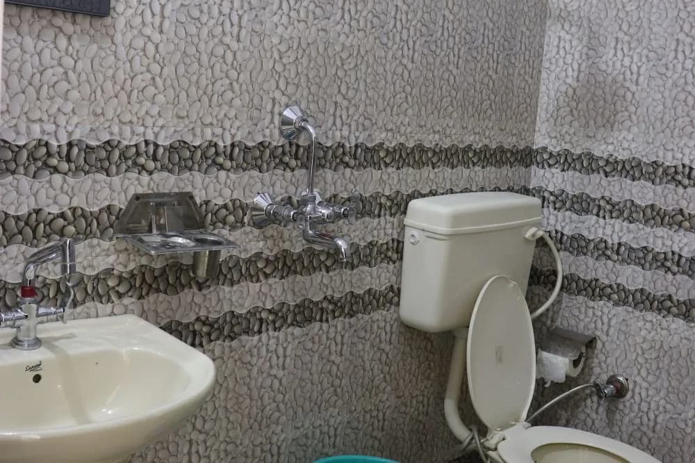 Clean attached bathroom with hot-water shower at the Deep Yoga shala